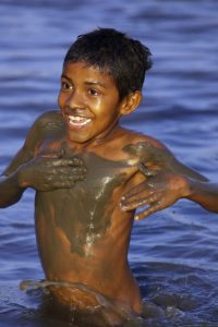 Einheimischer Junge nach einem Schlammbad in Kolumbien